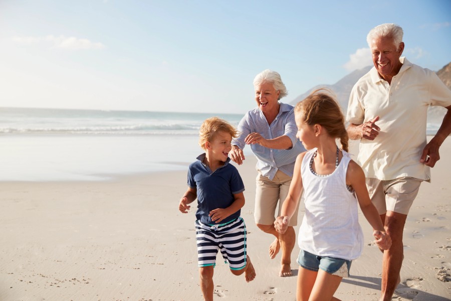 Grandparents playing with grandchildren on the beach